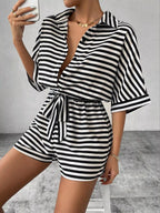 Striped button-up belted romper by Trendsi featuring a stylish design, lightweight fabric, and a waist belt for a chic summer look.