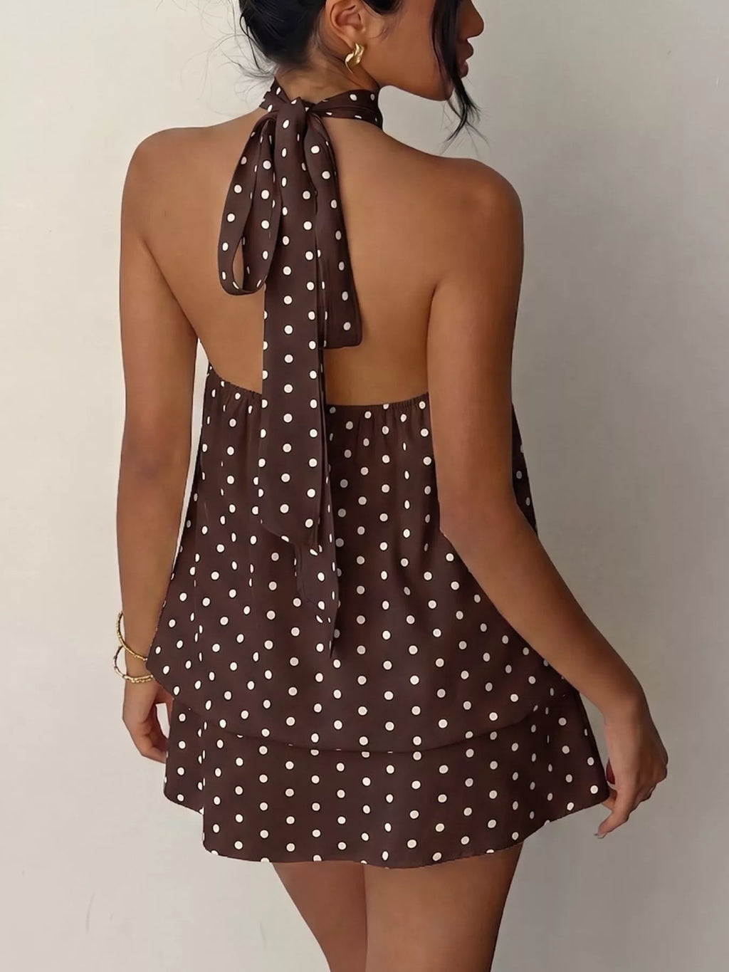 Polka dot halter neck mini dress by Trendsi featuring a fitted bodice and playful polka dot pattern.