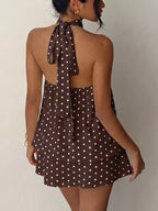 Polka dot halter neck mini dress by Trendsi featuring a fitted bodice and playful polka dot pattern.