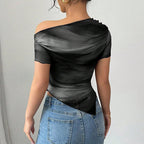 Black and grey abstract print, off-shoulder short-sleeve crop top with a draped neckline and pointed asymmetrical hem.