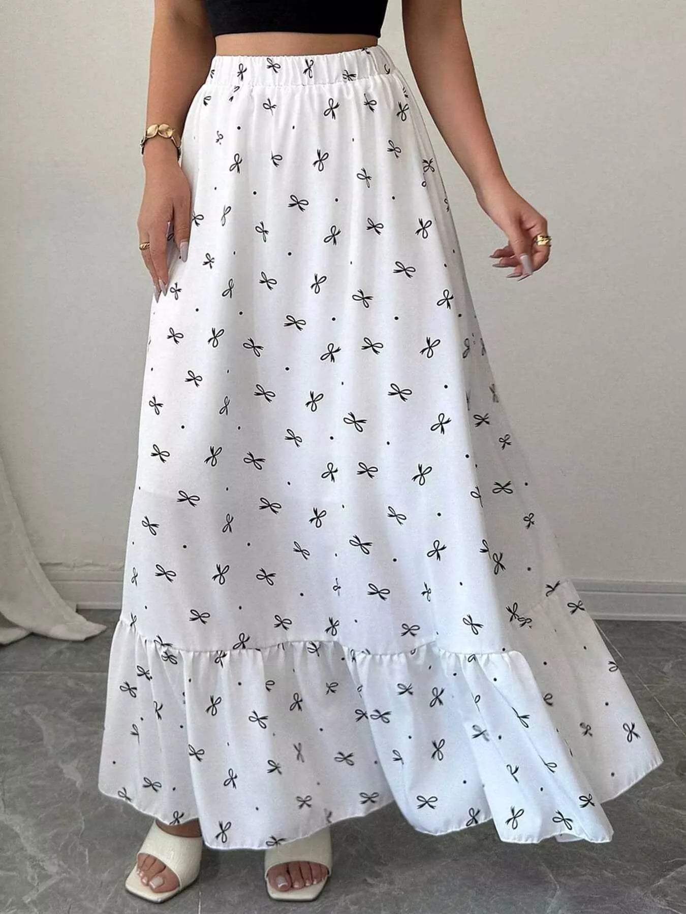 Trendsi bowknot print ruffle hem maxi skirt with flowing fabric and waist tie, showcasing a stylish, feminine design.