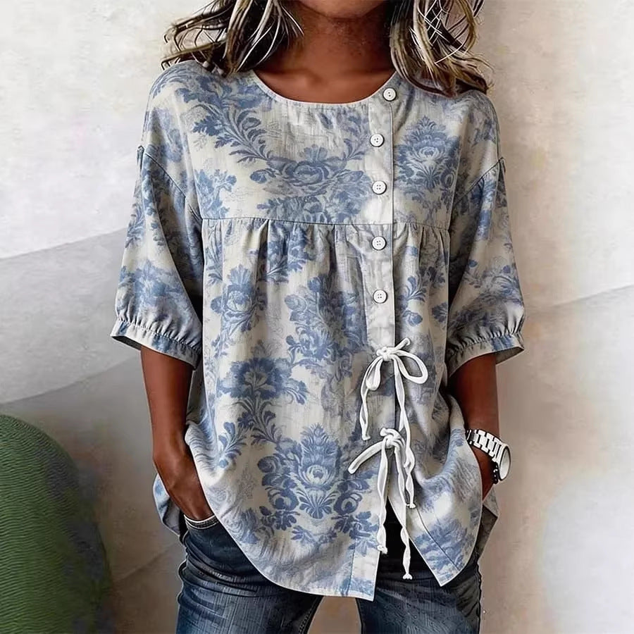 Blue and cream floral print tunic with short puff sleeves, side button detail, and white drawstring tie closure.