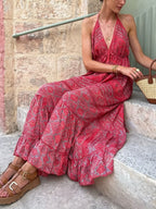 Elegant tiered halter neck maxi dress by Trendsi featuring flowing fabric and a stylish design perfect for summer events.