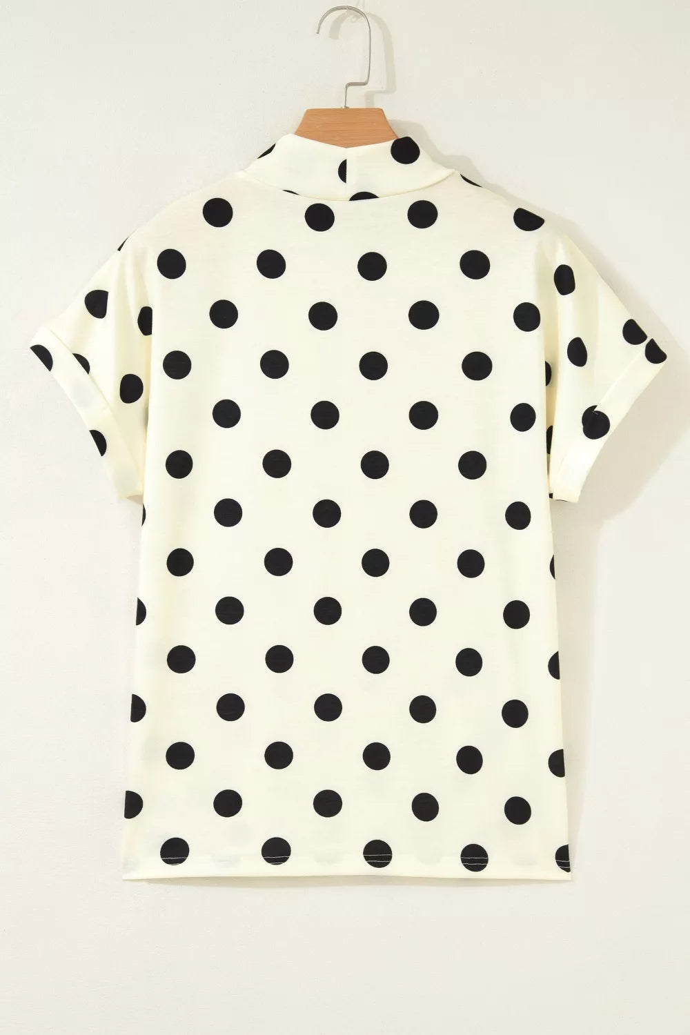 Polka dot print high neck dolman top from Trendsi, featuring a relaxed fit and stylish design, displayed on a hanger.