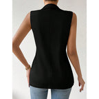 Back view of a woman wearing a sleeveless black tailored vest with a collared neckline, paired with blue jeans.