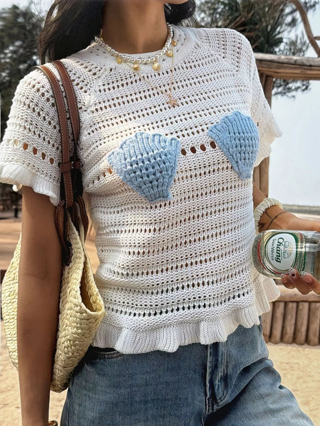 Openwork ruffled hem knit top by Trendsi featuring a breathable openwork design and feminine ruffled hem detail.