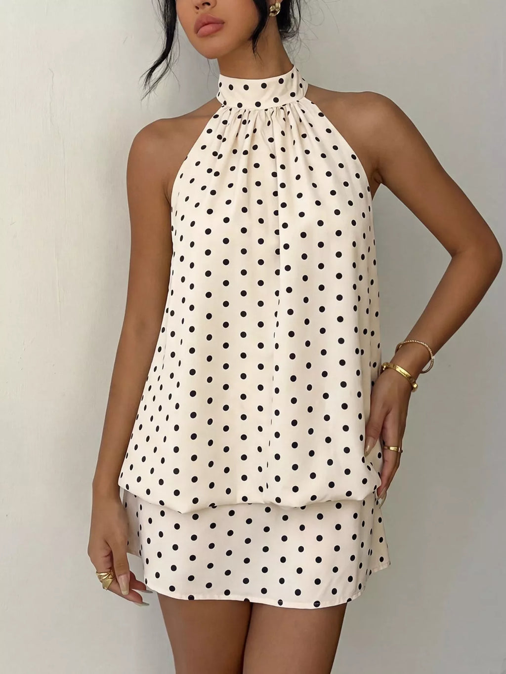 Polka dot halter neck mini dress by Trendsi, showing the stylish sleeveless design with a fitted waist and playful pattern.
