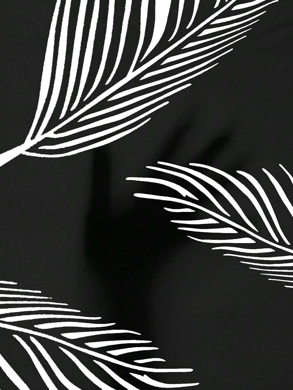 Close-up of black fabric with white, minimalist line-drawn palm leaf patterns.