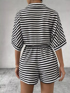 Striped button-up belted romper by Trendsi featuring long sleeves, a waist belt, and a casual, stylish design.