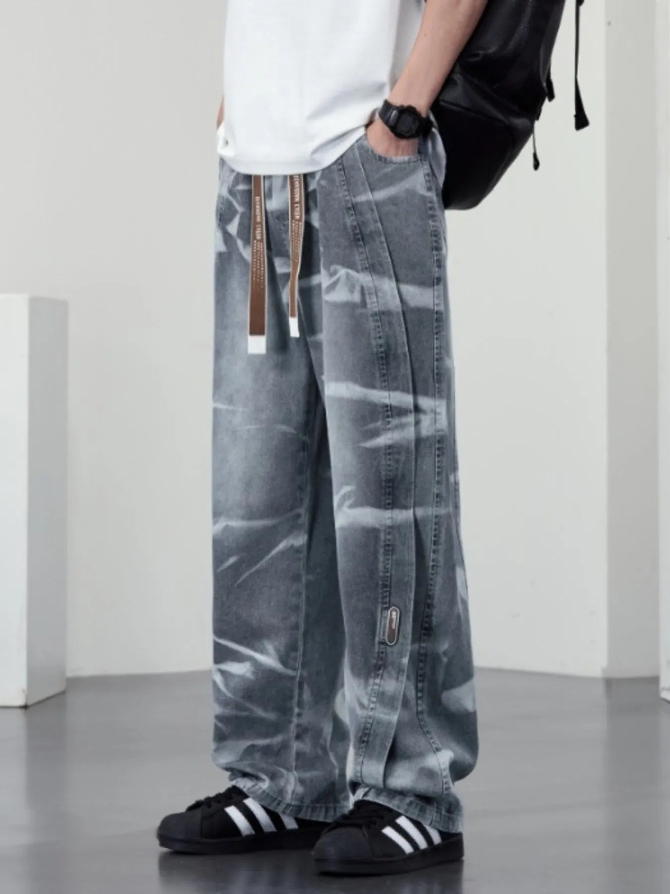 Men's plus size washed wide-leg jeans by Trendsi, showing a relaxed fit with distressed details and classic denim texture.