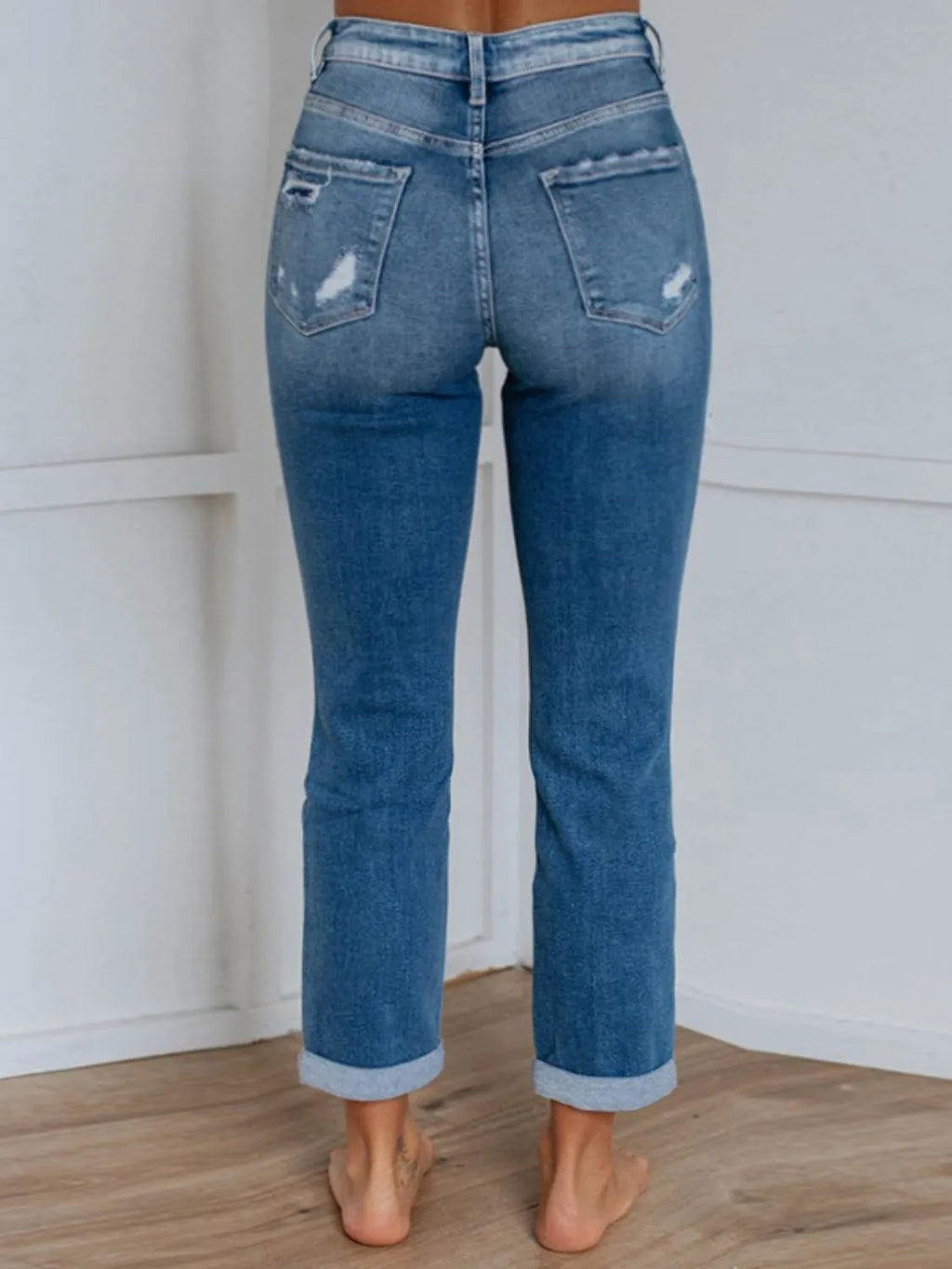 Distressed denim jeans with front and back pockets from Trendsi, showcasing a casual, worn-in style.