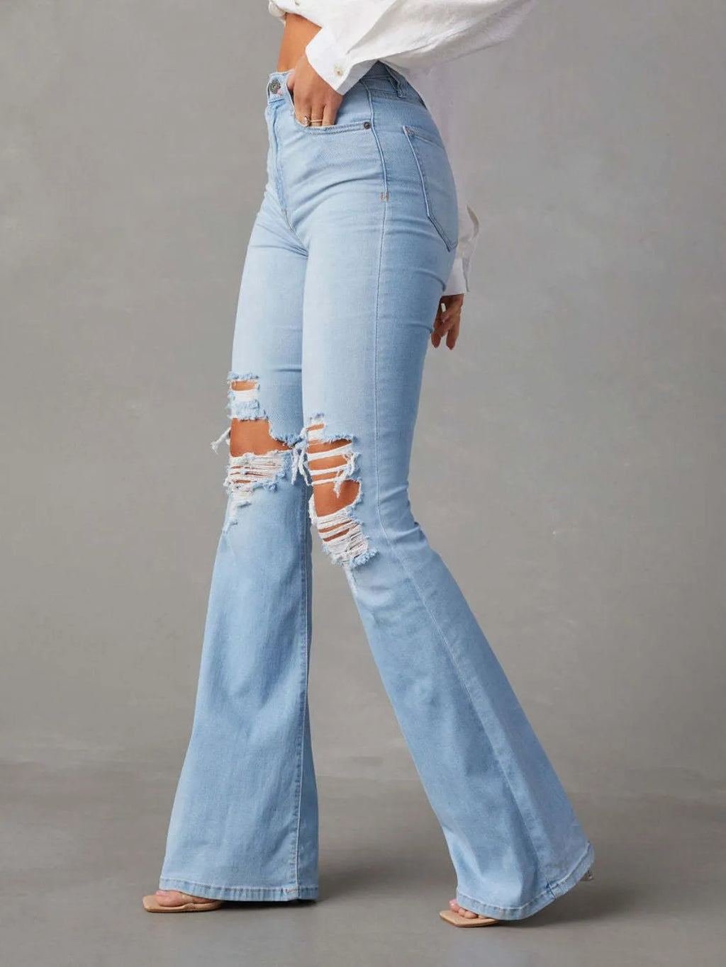 Distressed jeans with front and back pockets from Trendsi, featuring a ripped, casual denim style.