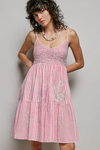 Women's sleeveless striped smocked embroidered cotton mini dress with a fitted bodice and flared skirt, casual summer style.