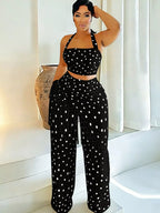 Polka dot halter neck cami with fringe trim pants set by Trendsi, featuring a stylish halter top and matching wide-leg pants with fringe details.
