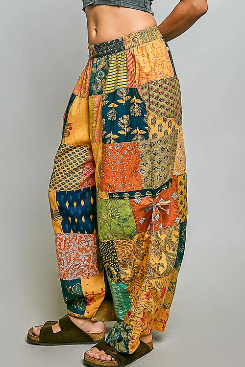Printed patchwork wide-leg cotton pants with side drawstring, styled as a casual dress, showcasing colorful fabric and relaxed fit.