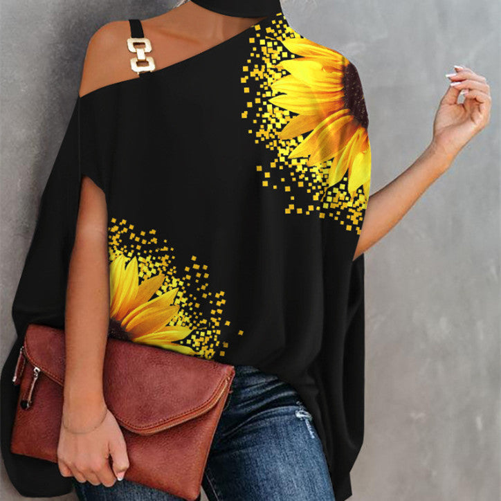 Black off-shoulder top featuring a pixelated yellow sunflower print and a decorative gold-tone shoulder link.