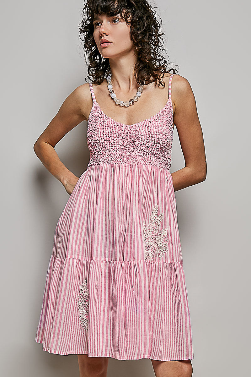 Women's sleeveless striped smocked embroidered cotton mini dress by Trendsi, featuring a fitted bodice and colorful striped pattern.