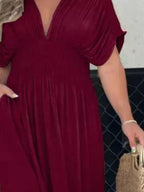 Plus size maxi dress with slit V-neck and smocked waist by Trendsi, featuring a flowing silhouette and elegant design.
