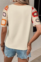Geometric print round neck short sleeve blouse from Trendsi, featuring a stylish pattern and comfortable fit for casual wear.