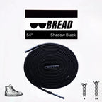 Black elastic shoelace by Bread, classic shadow black color, shown threaded through shoe eyelets for a snug fit.