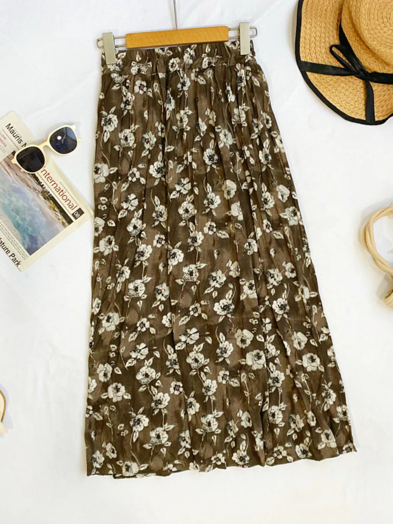Floral print elastic waist midi skirt from Trendsi, featuring a flowing design and vibrant blossom patterns.