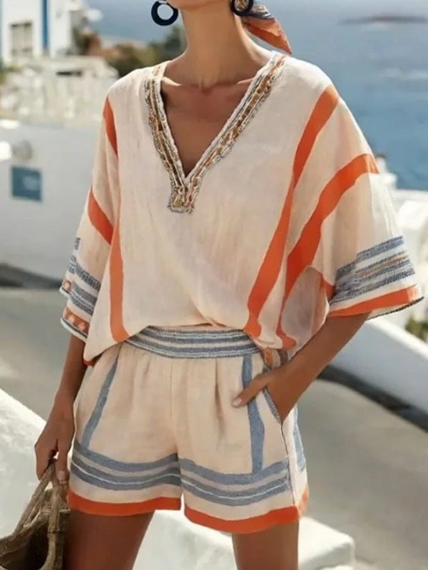 Beige two-piece set with orange and blue stripes, v-neckline, beaded trim, and relaxed-fit shorts.