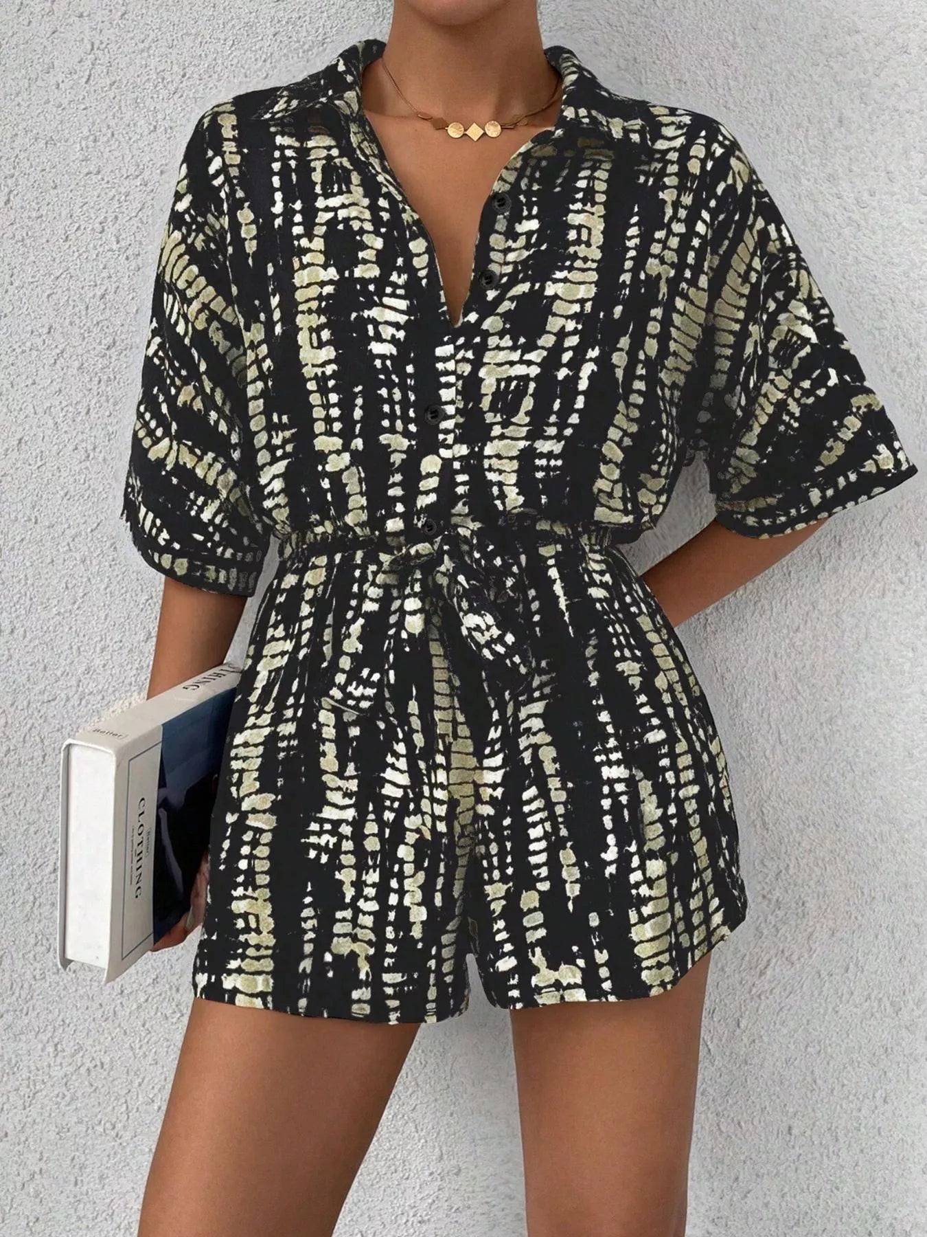 Striped button-up belted romper from Trendsi featuring a stylish design with a collar and waist tie, perfect for casual wear.