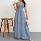 Dusty blue halter-neck maxi dress with a ruched bodice and a tiered, flowing skirt.