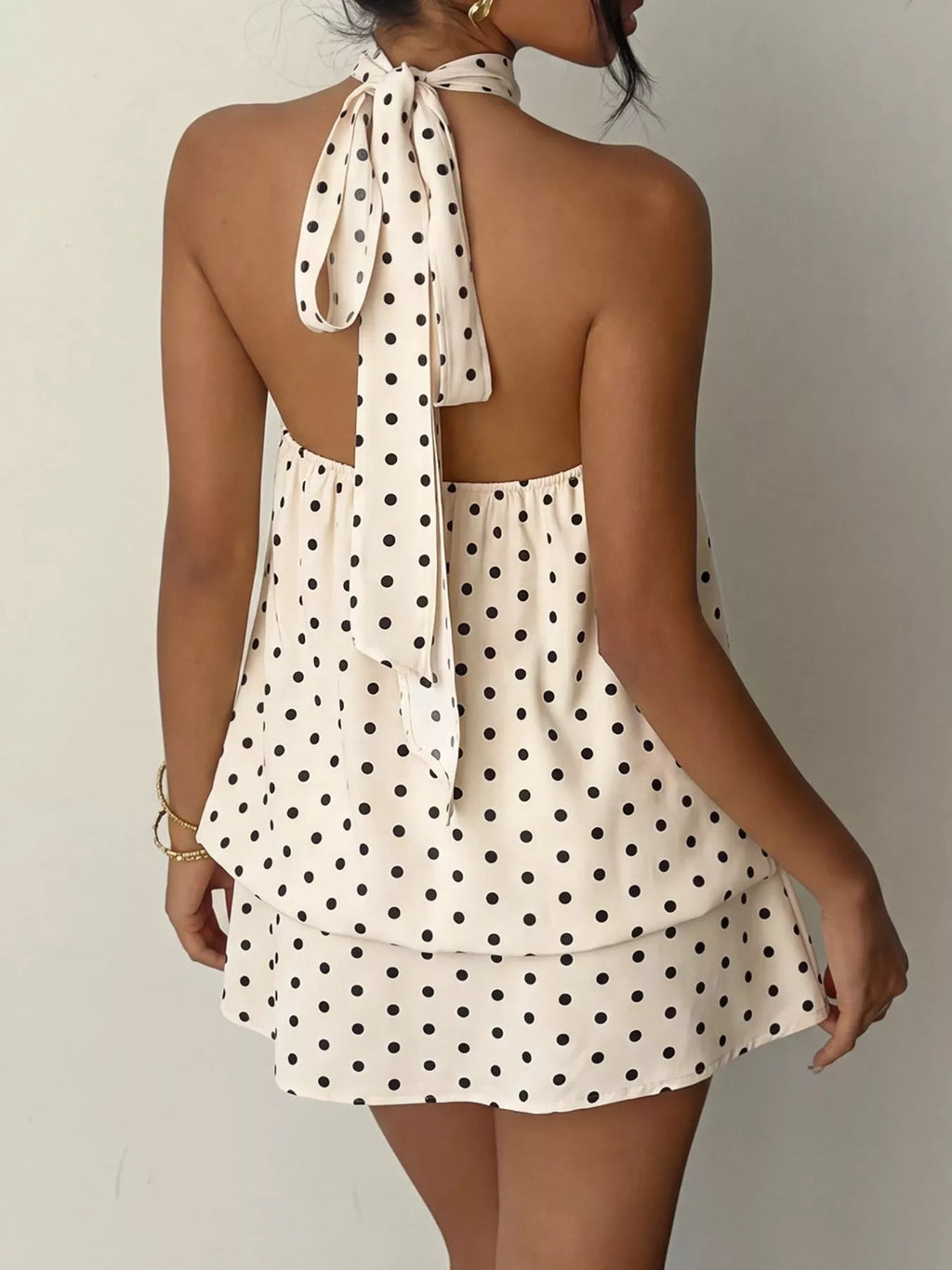 Polka dot halter neck mini dress from Trendsi, featuring a sleeveless design and playful black and white polka dot pattern.