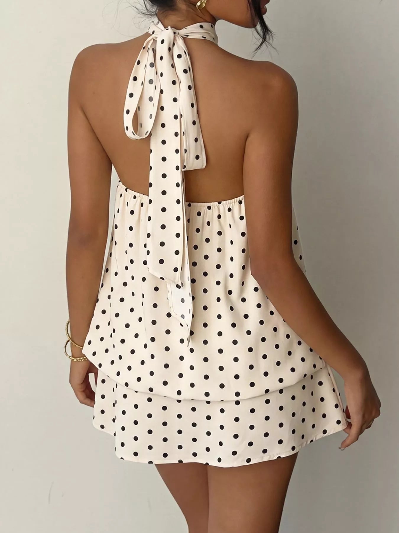 Polka dot halter neck mini dress from Trendsi, featuring a sleeveless design and playful black and white polka dot pattern.