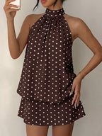 Polka dot halter neck mini dress by Trendsi featuring a stylish, sleeveless design with a fitted waist and playful pattern.