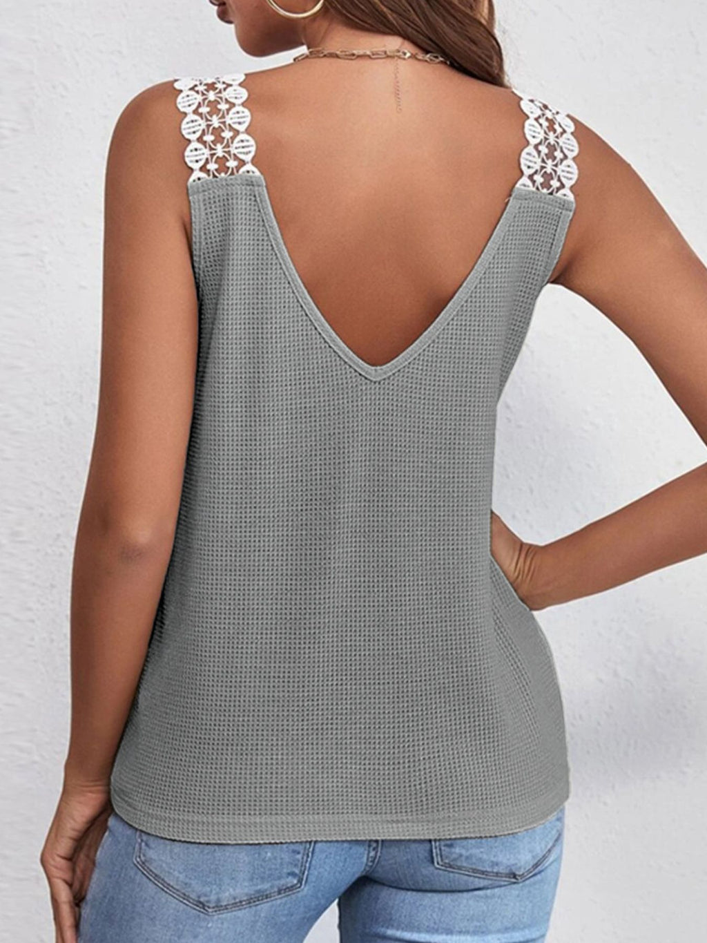 Women's V-neck waffle knit tank top with lace trim, featuring a soft texture and delicate detailing, perfect for casual wear.