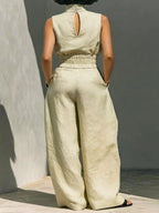 Sleeveless turtleneck top and wide-leg pants set by Trendsi, featuring a fitted turtleneck and flowing pant legs in neutral fabric.