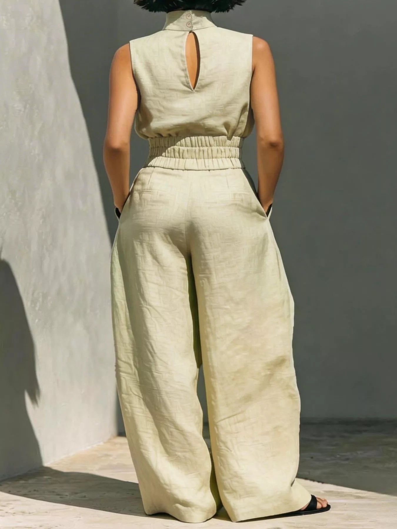 Sleeveless turtleneck top and wide-leg pants set by Trendsi, featuring a fitted turtleneck and flowing pant legs in neutral fabric.