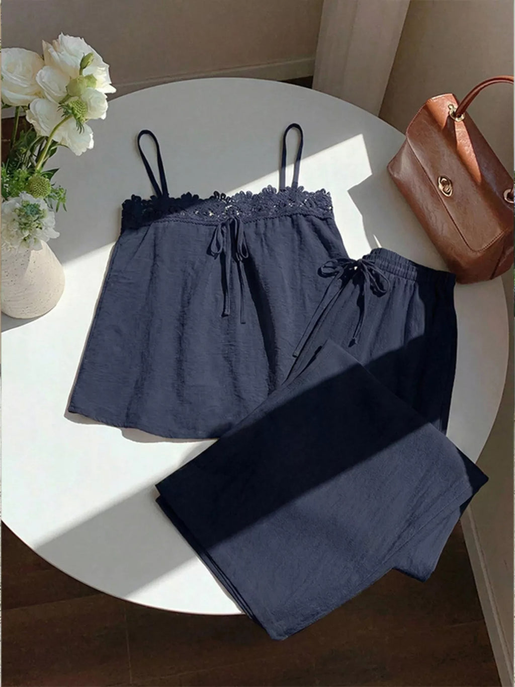 Lace trim cami and wide-leg pants set by Trendsi, featuring lightweight fabric, delicate lace details, and a relaxed fit.