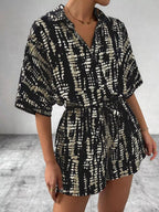 Striped button-up belted romper by Trendsi featuring a stylish design and front buttons on lightweight fabric.