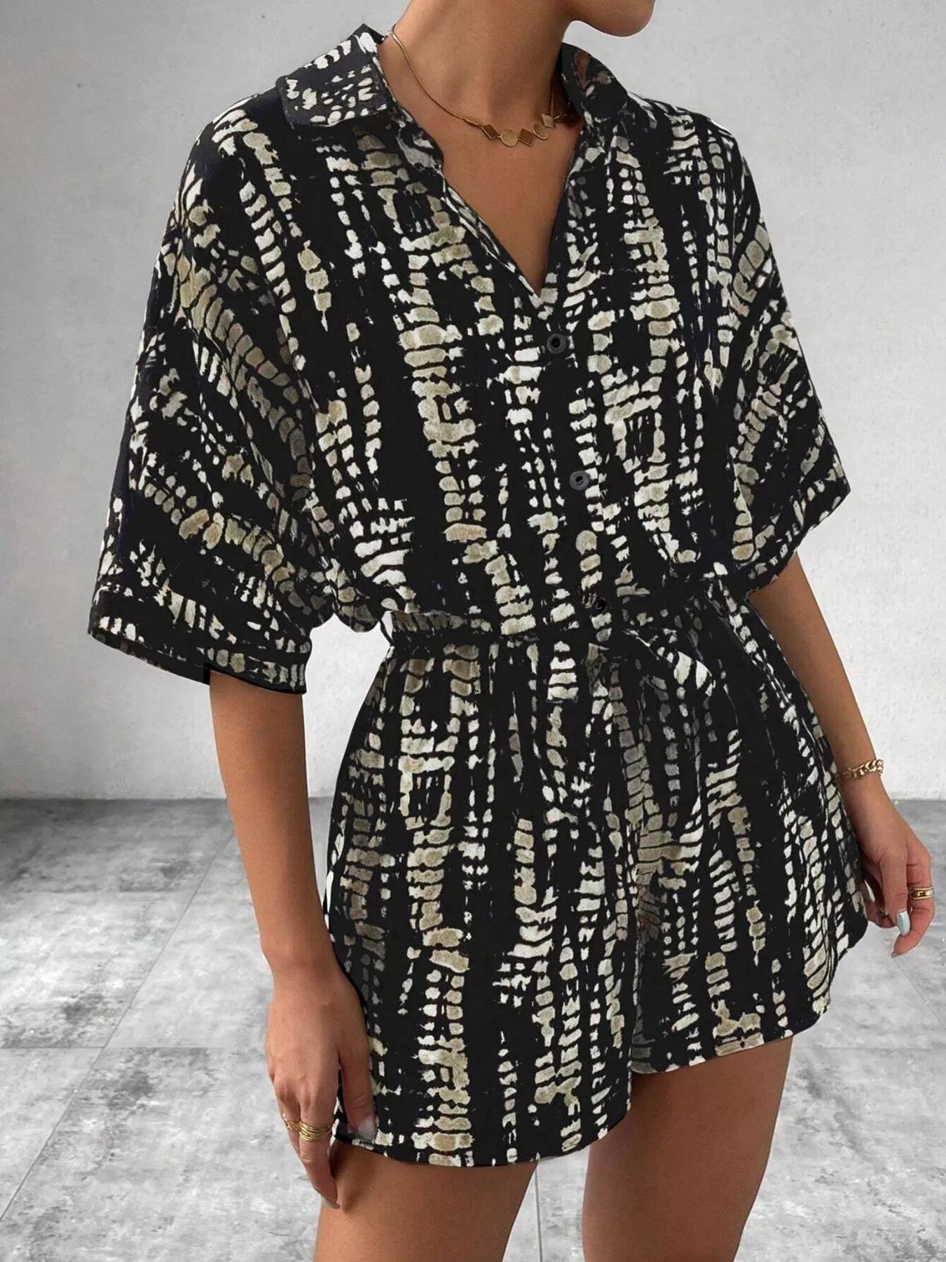 Striped button-up belted romper by Trendsi featuring a stylish design and front buttons on lightweight fabric.