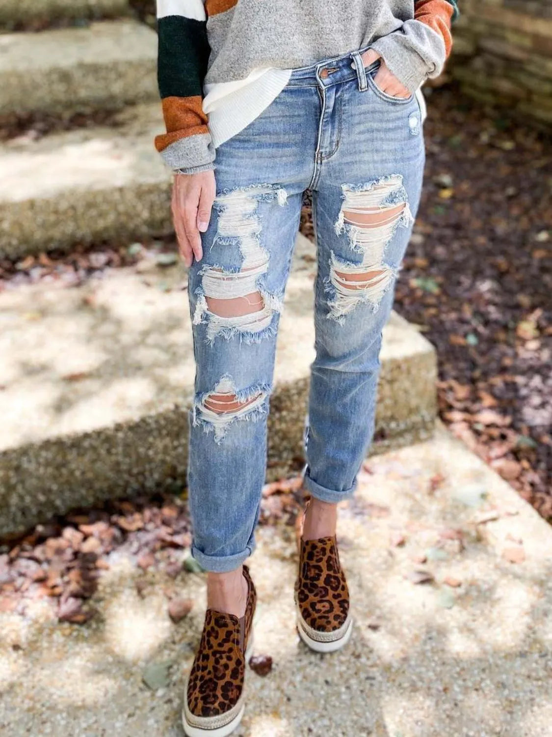 Distressed skinny jeans by Trendsi featuring ripped details and a fitted silhouette, shown on a model in a casual setting.