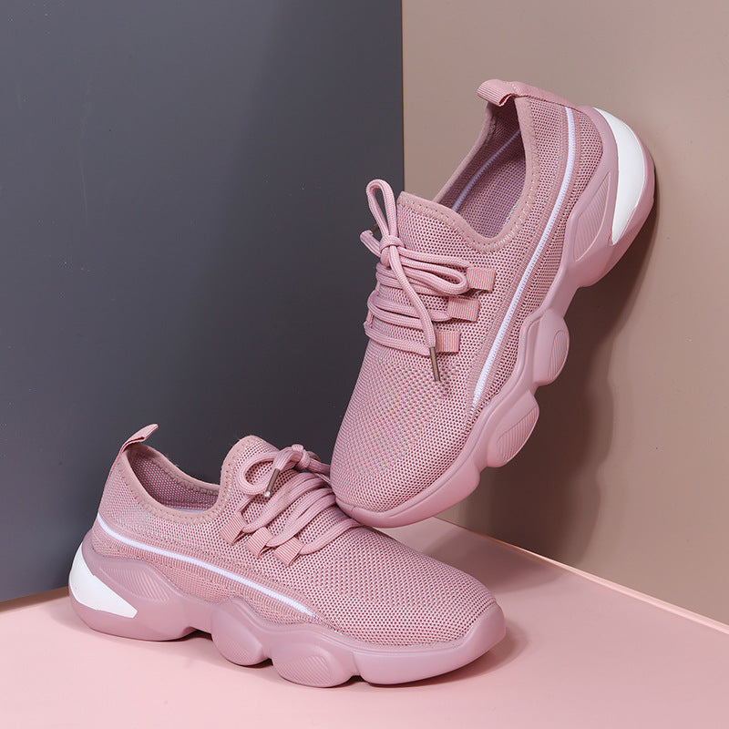 Light pink breathable mesh sneakers with chunky soles, lace-up closures, and white accents on a two-tone background.