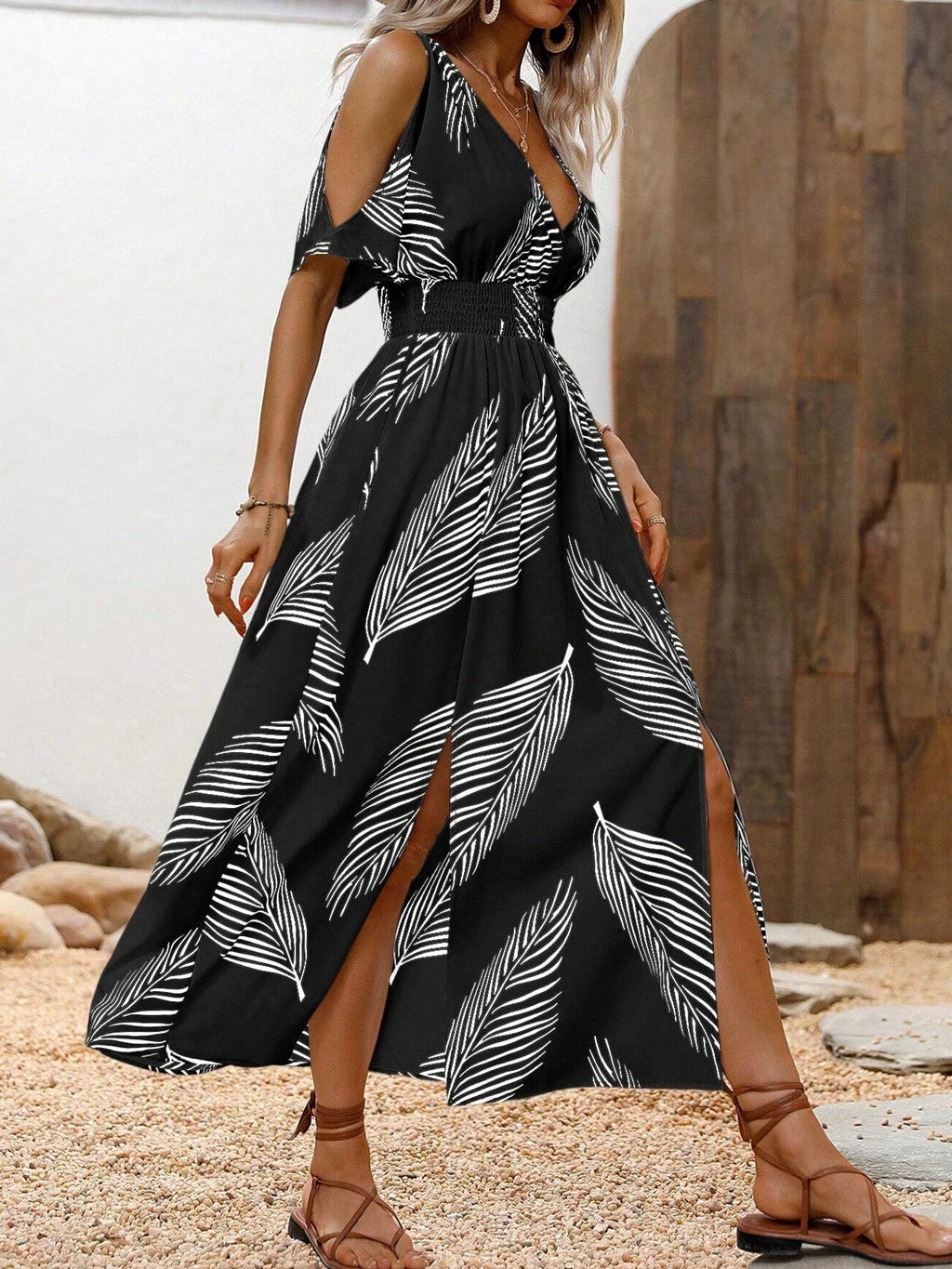 Black and white leaf-print maxi dress with cold shoulders, a V-neck, cinched waist, and front leg slits.