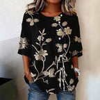 Black blouse with beige floral embroidery, short sleeves, white buttons, and a front drawstring tie detail.