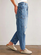 Distressed denim jeans with front and back pockets by Plush Fashion Shop, showcasing a trendy, ripped fashion style.