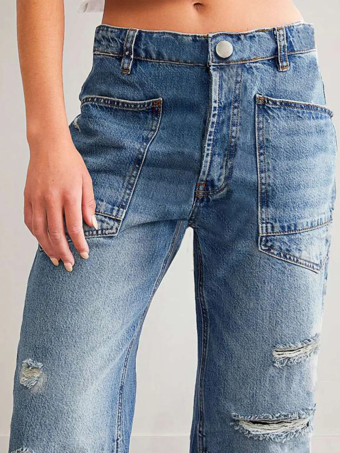 Distressed denim jeans with pockets from Plush Fashion Shop, featuring a trendy, worn-in look and classic five-pocket design.
