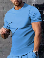 Men's plus size casual T-shirt in solid color from Trendsi, showing front view with round neckline and relaxed fit.