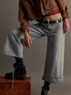 Pair of plush fashion shop wide-leg cropped denim jeans hanging on a rack, showcasing relaxed fit and stylish design.
