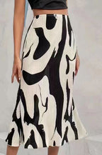 High-waisted, cream and black abstract-print pleated midi skirt paired with a black crop top.