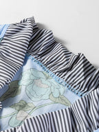 Floral print ruffled v-neck blouse with striped trim, stylish women's top from Trendsi featuring feminine design and lightweight fabric.