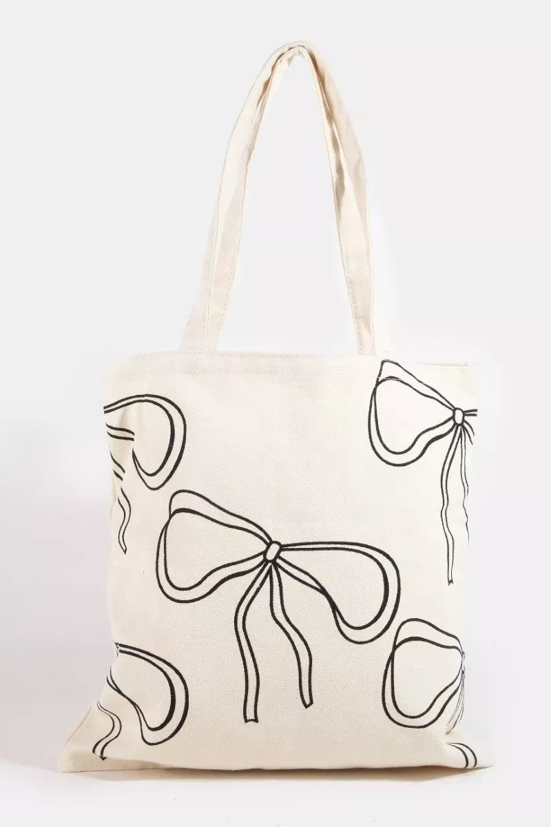 Lightweight polyester tote bag with feminine ribbon bow tie print, shoulder strap, and spacious interior for everyday use.