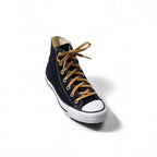 Black high-top canvas sneaker with a white rubber toe cap, white sole, and contrasting tan shoelaces.