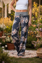 Model in a white crop top wearing dark navy floral print wide-leg lounge pants with a gray drawstring waistband.